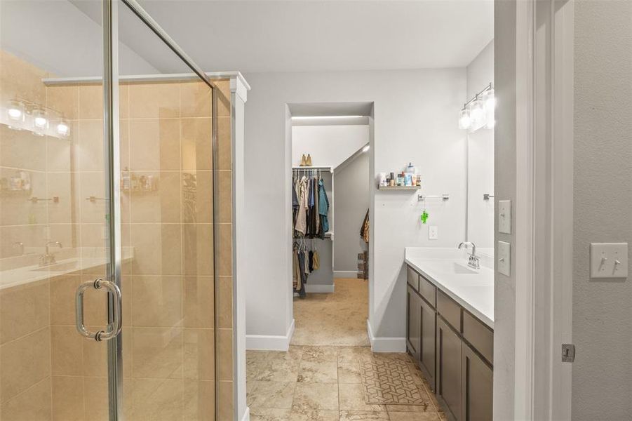 Bathroom featuring tile patterned floors, a shower with door, and vanity