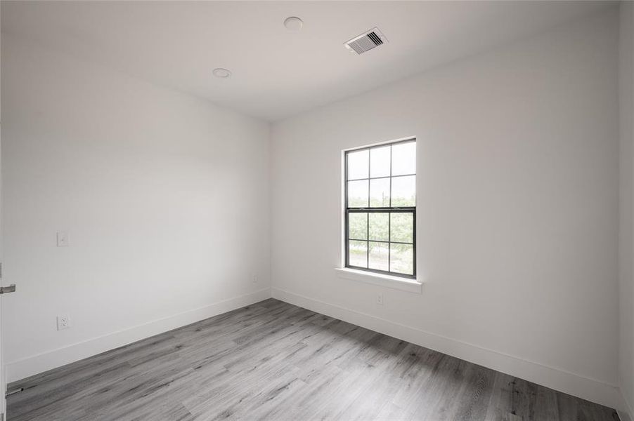 *Representative Photo. A modern bathroom with sleek gray cabinetry, a white marble countertop, large mirror, and tub shower.*Representative Photo. Primary Bedroom walk-in closet with ample hanging space, featuring modern gray flooring.*Representative Photo. Private Fenced outdoor space.*Representative Photo. Home may be under construction.