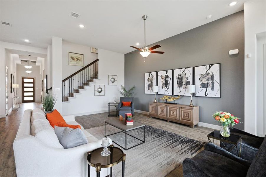 Living room with ceiling fan and hardwood / wood-style floors