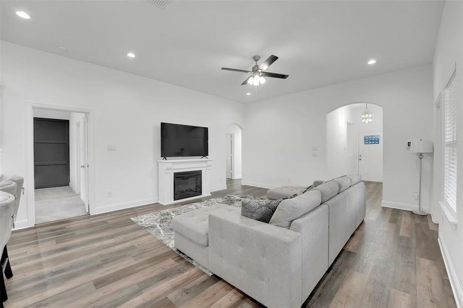 Living room with light hardwood / wood-style floors and ceiling fan