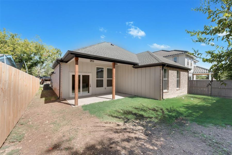 Rear view of property with a yard and a patio