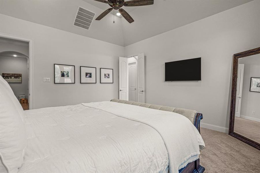 Bedroom with ceiling fan, high vaulted ceiling, and carpet flooring