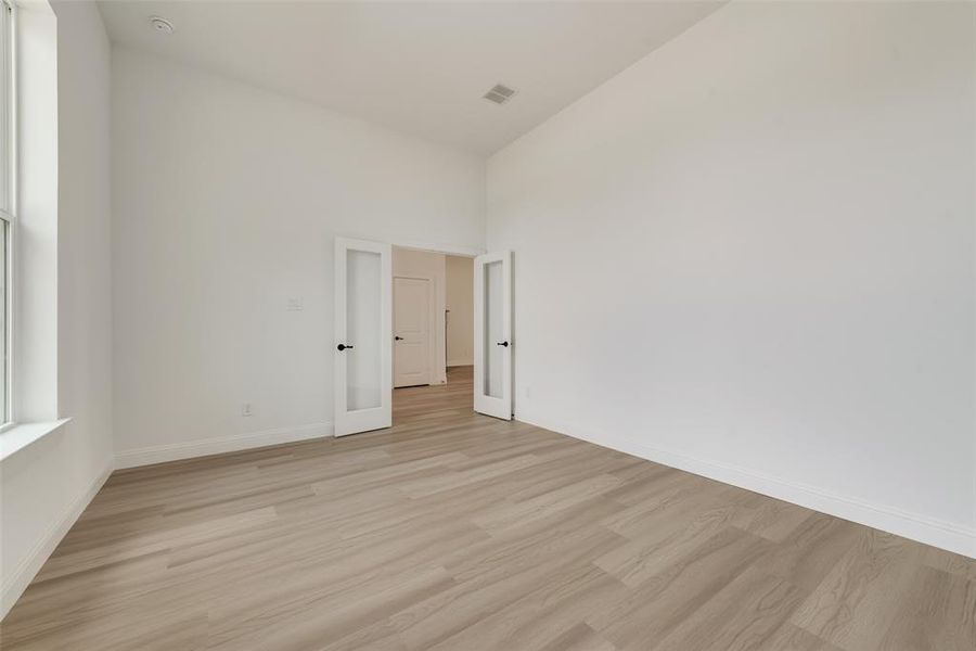 Unfurnished room featuring high vaulted ceiling and light hardwood / wood-style floors