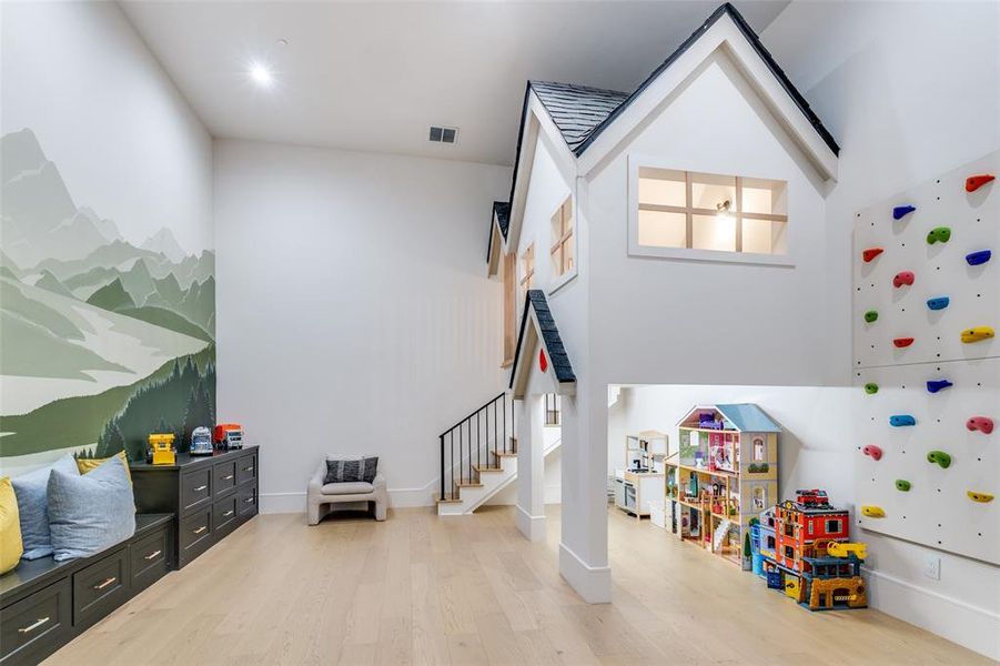 Game room featuring a high ceiling and light hardwood / wood-style flooring