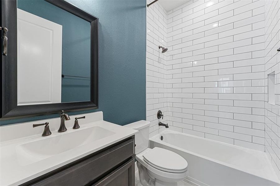 This full bath is a showstopper, featuring stunning white shower tiles that stretch all the way to the ceiling.