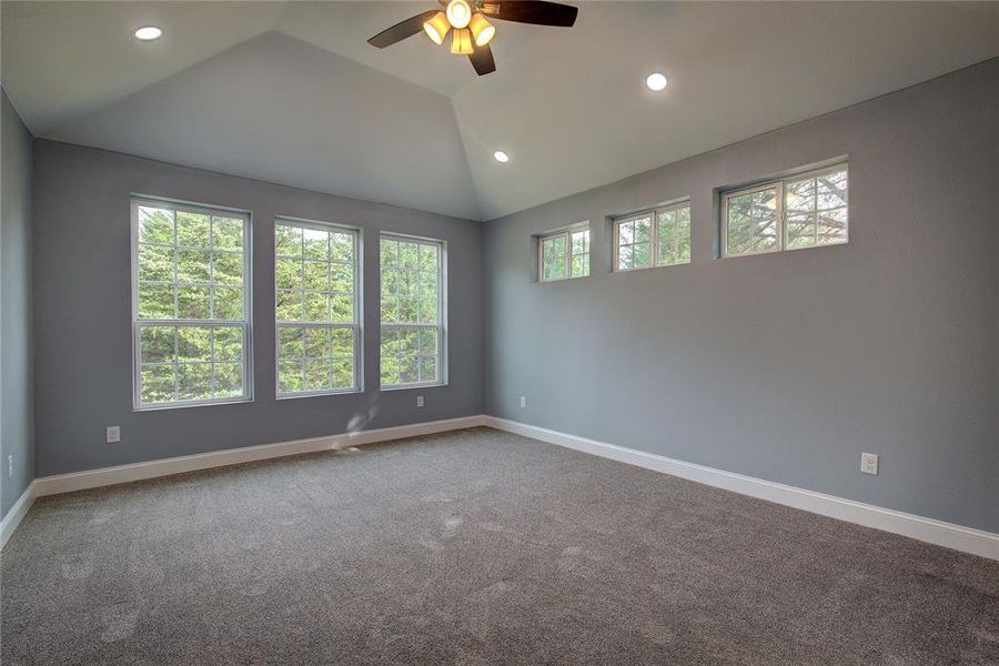 Master bedroom with carpet, ceiling fan , canned lighting and vaulted ceiling