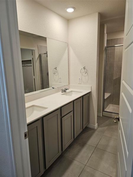 Bathroom with vanity, tile patterned floors, and walk in shower