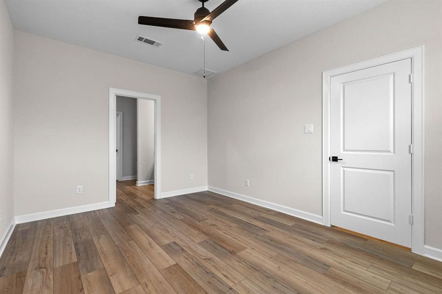 In the primary bedroom, vinyl plank flooring creates a foundation of modern elegance, while a ceiling fan provides a soothing breeze on warm nights.