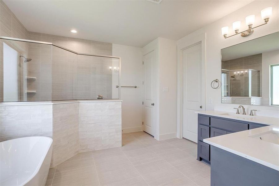 Bathroom featuring tile flooring, vanity, and plus walk in shower