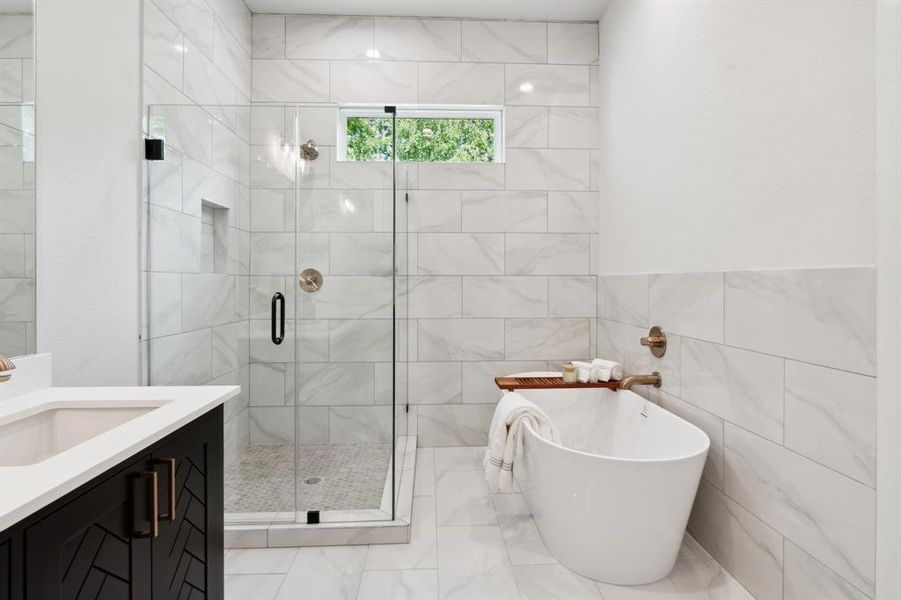 Experience sheer luxury in the primary bathroom, where a breathtaking combination of an oversized standalone tub and meticulously designed walk-in shower showcases an extraordinary attention to detail and design.