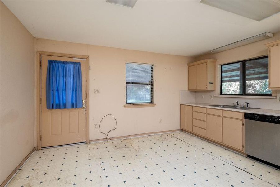 Kitchen with dishwasher, sink, and light brown cabinets