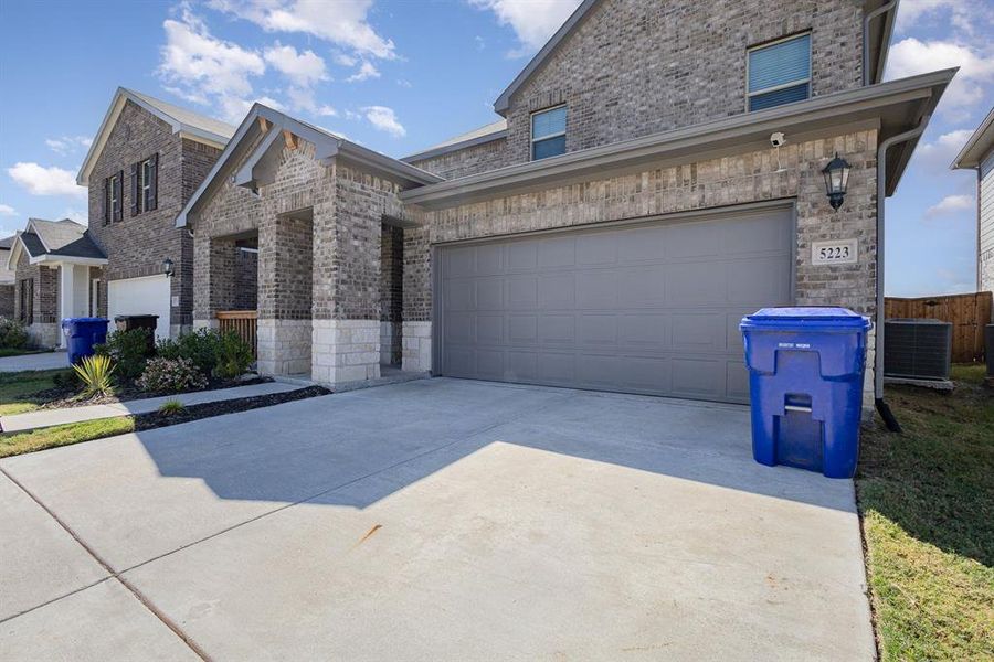 View of front facade with a garage and central AC unit