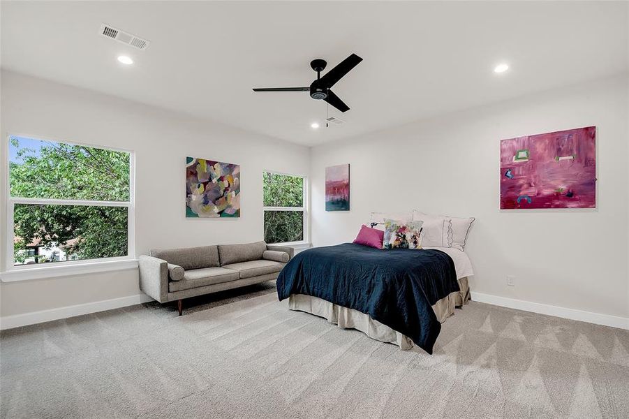 Carpeted Primary Bedroom featuring ceiling fan