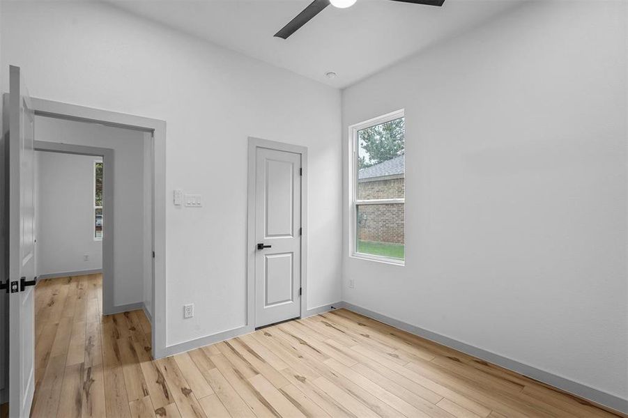 Unfurnished bedroom with ceiling fan and light hardwood / wood-style floors