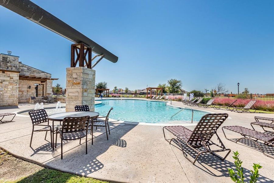 View of pool featuring a patio and an outdoor stone fireplace