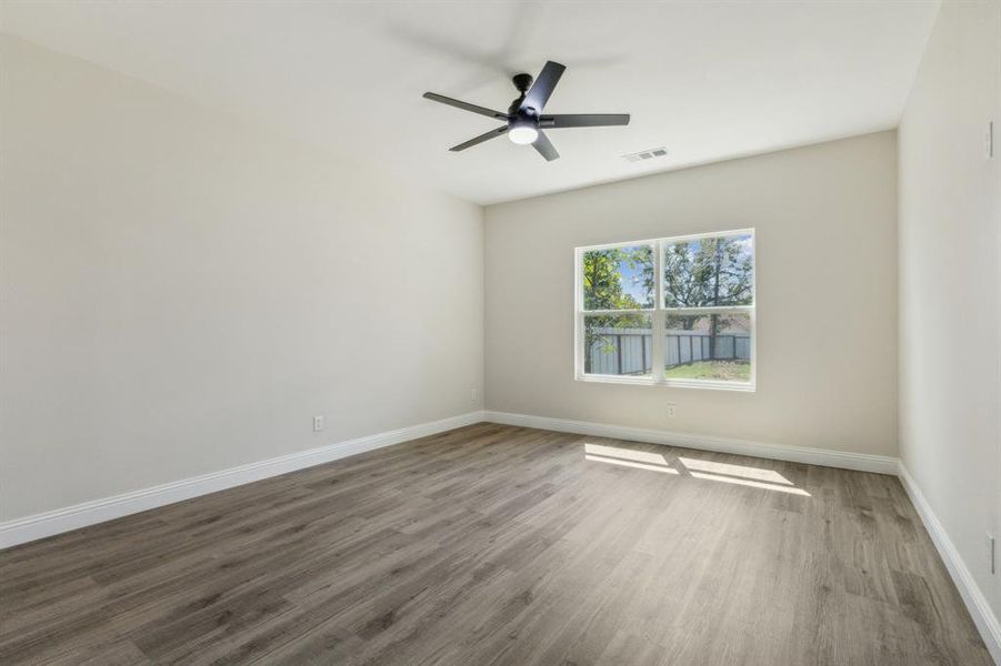 Empty room with ceiling fan and dark hardwood / wood-style floors