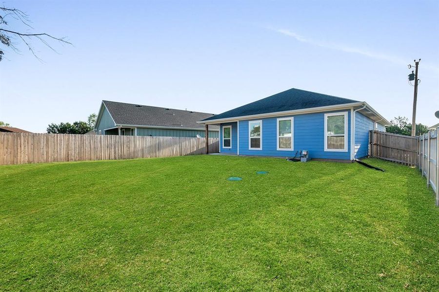 Rear view of house with a lawn