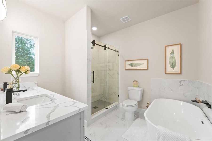 This is a modern bathroom with a double vanity, marble countertops, a freestanding tub, a separate glass-enclosed shower, and a window with a view of greenery.