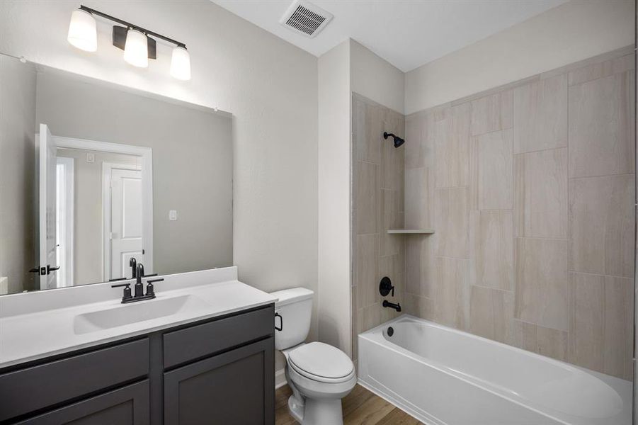 The second bathroom features attractive tiled tub/shower combination.