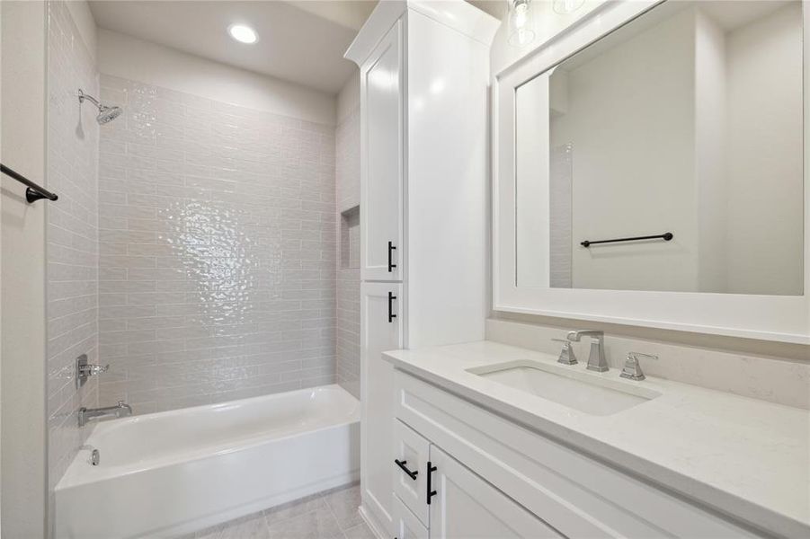 Bathroom featuring vanity and tiled shower / bath