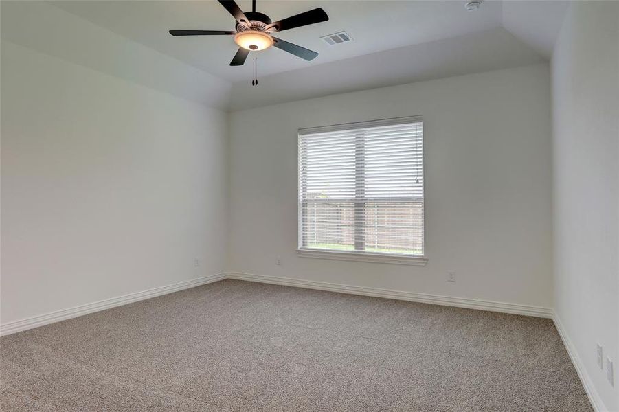 Unfurnished room with vaulted ceiling, carpet, and ceiling fan