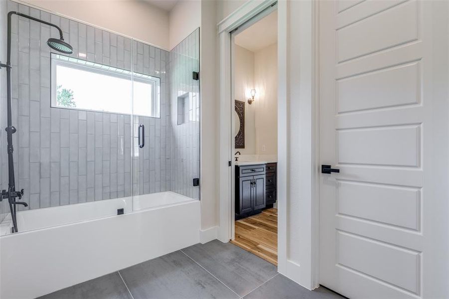 Bathroom featuring vanity, bath / shower combo with glass door, and hardwood / wood-style floors