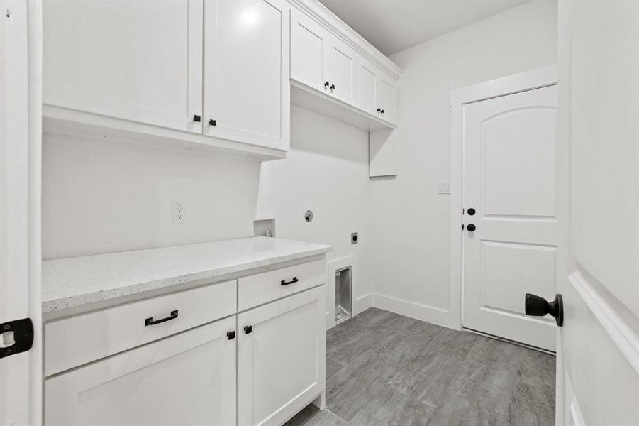 Clothes washing area featuring cabinets, electric dryer hookup, and washer hookup