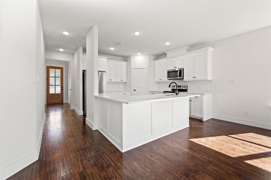 Kitchen featuring stainless steel appliances, dark hardwood / wood-style floors, sink, and white cabinets