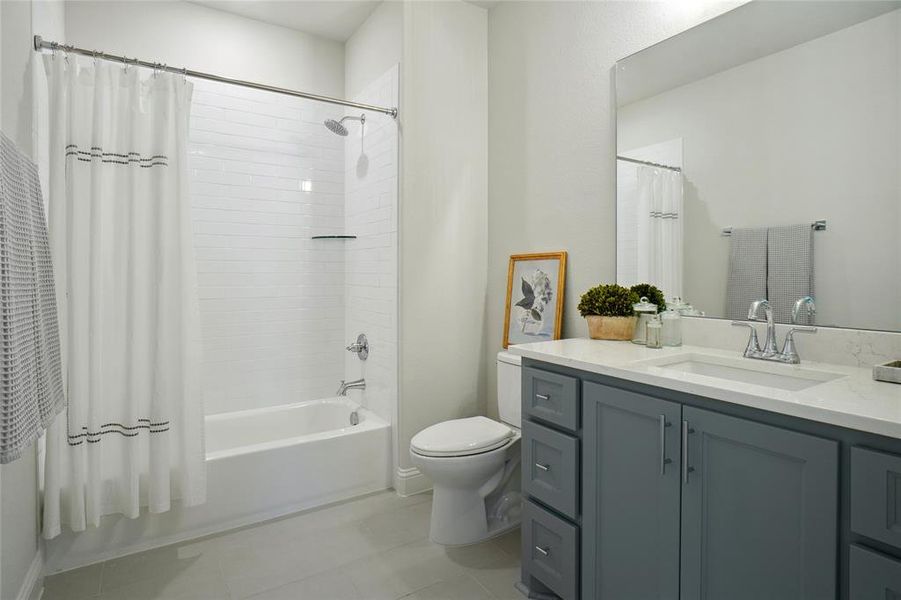 Full bathroom with vanity, tile patterned flooring, toilet, and shower / bath combo