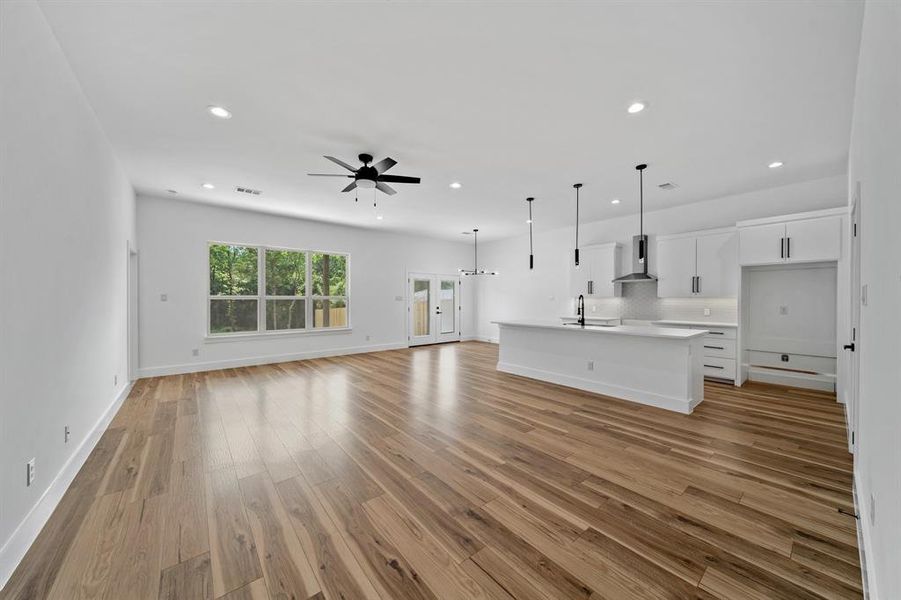 Unfurnished living room featuring sink, light wood-type flooring, and ceiling fan