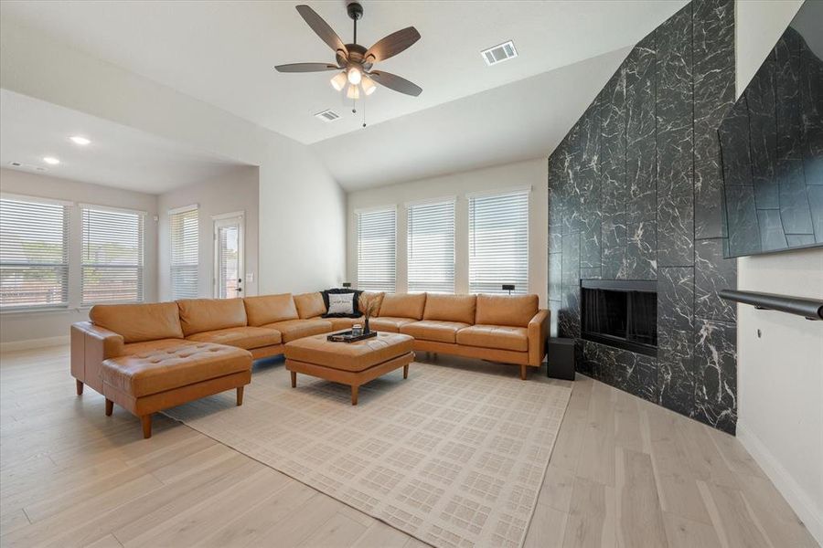 Living room with ceiling fan, light hardwood / wood-style flooring, and a wealth of natural light