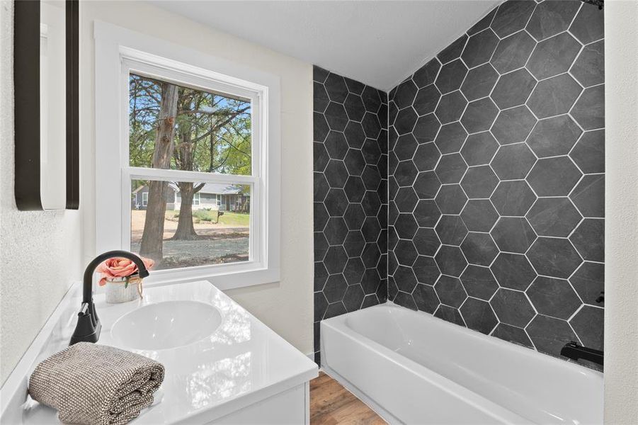 Bathroom with vanity, wood-type flooring, and a bathing tub