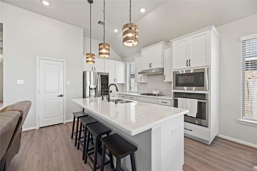 This modern kitchen features omega stone countertops and built-in stainless steel appliances