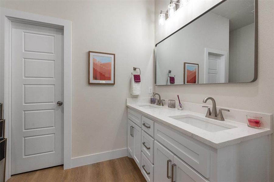 Bathroom luxury vinyl floors and dual vanity with granite counters