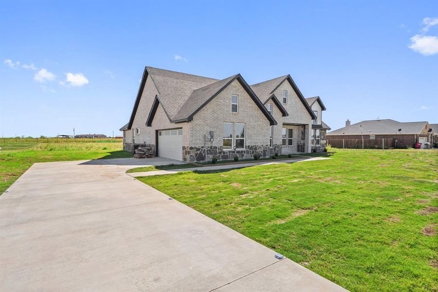 View of front of home with a garage and a front yard