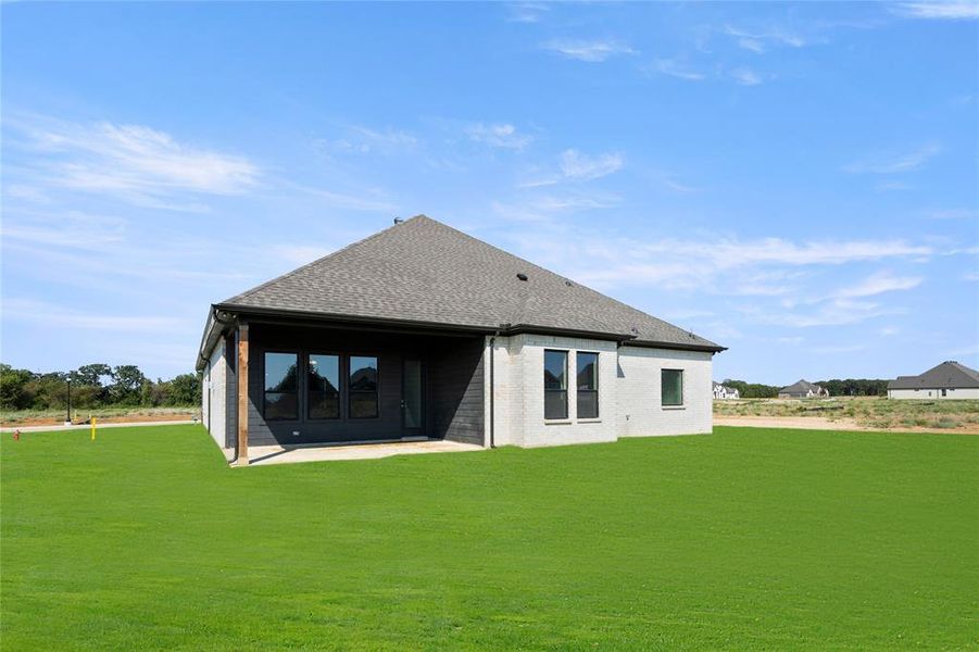 Back of house with a lawn and a patio area