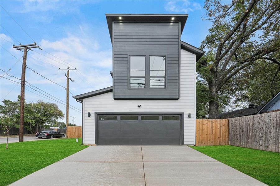 View of side of property with a lawn and a garage