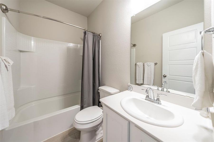 Full bathroom featuring vanity, toilet, tile patterned floors, and shower / bath combination