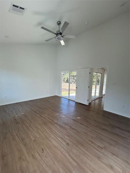 Master bedroom with wood-type flooring, ceiling fan, high vaulted ceiling, and plenty of natural light