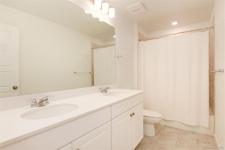 Upstairs hall bath wi th dual vanities and quartz counters.