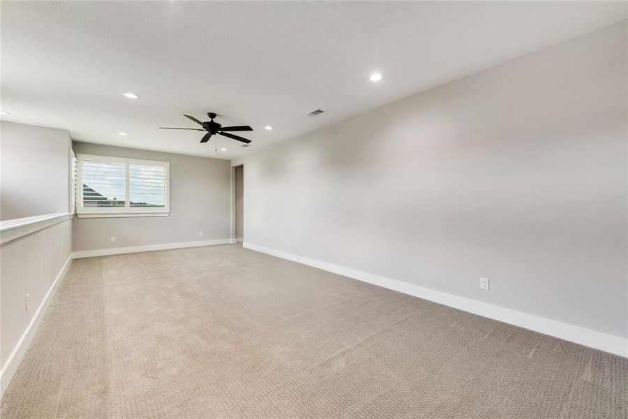 Spare room featuring ceiling fan and light colored carpet