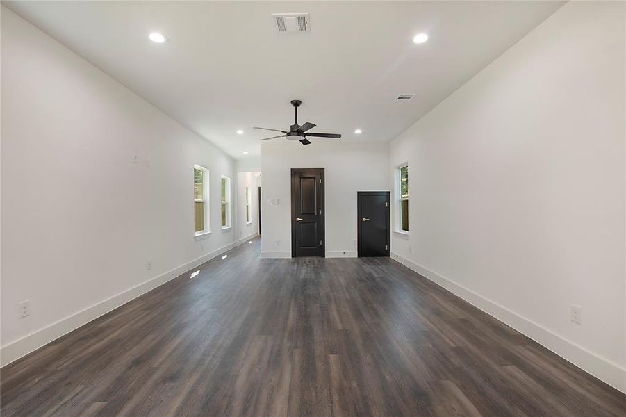 Empty room with ceiling fan and dark hardwood / wood-style floors