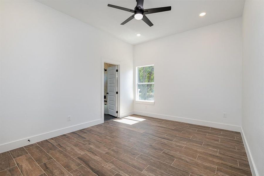 Unfurnished room featuring ceiling fan and dark hardwood / wood-style flooring