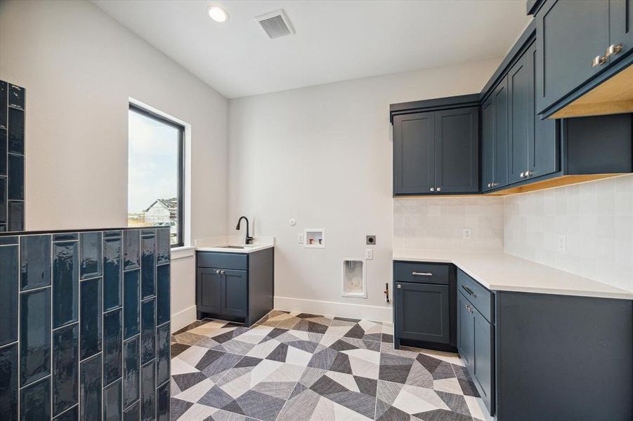 Laundry room with plenty of cabinet and counter space, plus a convenient dog wash!