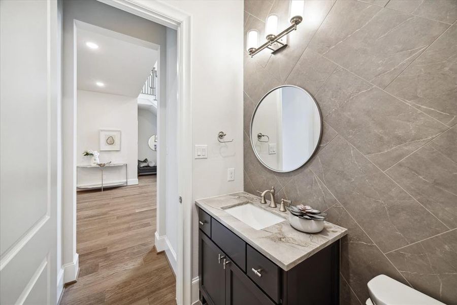 Elevate your guest experience with this impeccably designed powder room, featuring contemporary finishes and subtle yet sophisticated details. From the sleek vanity to the designer accents, every aspect has been carefully curated.