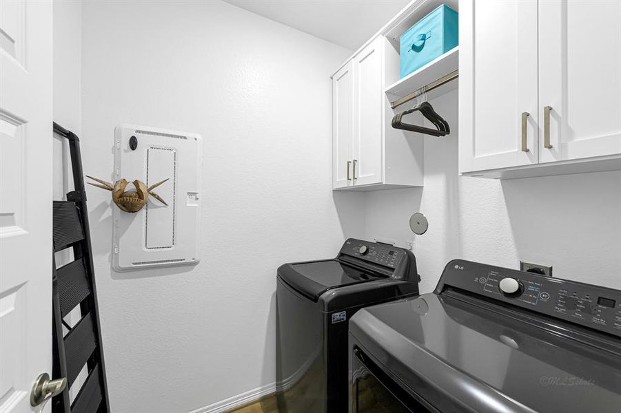 The laundry room features custom cabinetry that is typical of the design of the home and will help keep your laundry area looking "pintrest perfect".