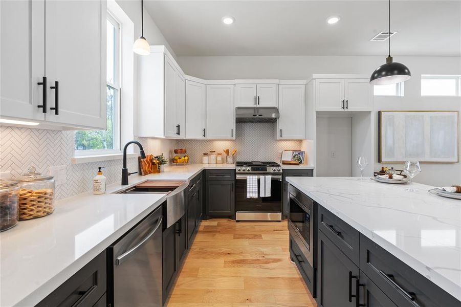 The kitchen's elegant backsplash features sleek herringbone pattern tile, imparting a timeless, classic appeal that effortlessly complements the space's overall design.