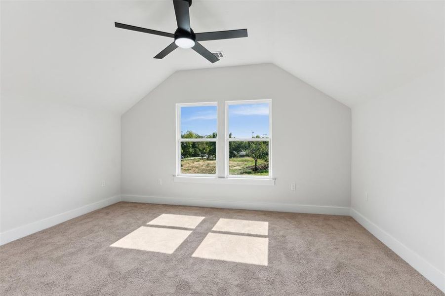 Bonus room featuring ceiling fan, vaulted ceiling, and light colored carpet