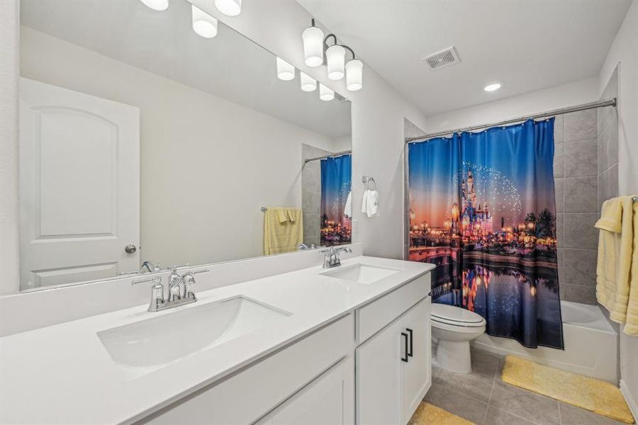 Full bathroom upstairs featuring tile patterned flooring, vanity, toilet, and shower / tub combo with curtain