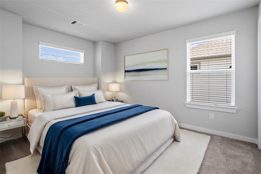 Secondary bedroom features plush carpet, custom paint, lighting, and large windows with privacy blinds.